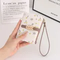 Nahaufnahme der süßen, geblümten Brieftasche mit Schnalle und Handgelenkschlaufe - Beige Aprikose