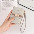 Nahaufnahme des hübschen Blumendrucks und der Handschlaufe der kurzen Damenbrieftasche - Graugrün