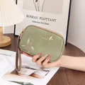 Elegant green double-zipper clutch bag featuring floral prints and a gold bird ornament. - Green