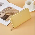 Elegant long yellow leather wallet with lychee texture and secure zip-around closure. - Yellow