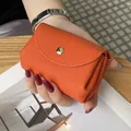 Compact orange genuine leather coin purse with an elegant pebble grain finish - Orange
