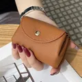 Handheld compact brown pebbled leather coin purse with a secure snap button closure - Earthy Yellow