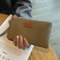 Small taupe litchi grain leather clutch bag with zipper and wrist strap detail - Gray