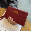 Elegant red genuine leather wristlet pouch with a fine lychee texture and gold zipper - Burgundy