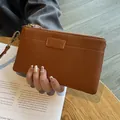 Premium compact brown pebble leather wristlet pouch featuring a gold zipper closure - Earthy Yellow