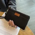 Small black genuine leather women's clutch bag with tan accent patch and gold zipper - Black