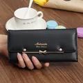 Detailed view of a black textured long wallet with a golden bow-knot and Meiruida logo - Black