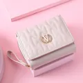 Elegant pink short wallet for women featuring quilted wave patterns and golden V logo. - White