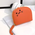 Small orange litchi grain leather coin purse featuring a cute cat face and tail zipper pull - Orange