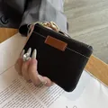 Handheld mini black pebbled leather coin purse with brown accent and white stitching - Black