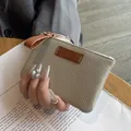 Elegant slim beige pebbled leather coin purse for women featuring a brown pull tab - Off-White