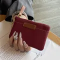 Elegant burgundy pebbled leather coin purse featuring a slim design and golden key hook - Burgundy