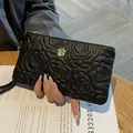 Elegant black embossed camellia pattern genuine leather clutch bag for women with gold hardware - Black