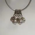 Detailed close-up of lobster clasp pearl pendants with ornate silver-toned flower caps. - Lobster Clasp Flower Cap Pearl Pendant / Pearl White