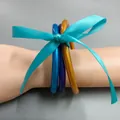 Nahaufnahme von drei glitzernden Jelly Bangles, mit einer blauen Schleife gebunden. - 3-lagiger mehrfarbiger Stil (Mix 3) / Innendurchmesser 65mm, 3er-Set / Blau Lila Gold Mix