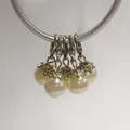 Detailed view of pearl pendants featuring ornate silver flower caps and lobster clasps. - Lobster Clasp Flower Cap Pearl Pendant / Milky White