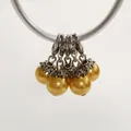 Close-up of five golden pearl charms featuring lobster clasps and ornate silver caps - Lobster Clasp Flower Cap Pearl Pendant / Gold