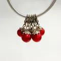 Detailed close-up view of five red pearl charms with ornate silver flower caps and lobster clasps - Lobster Clasp Flower Cap Pearl Pendant / Red