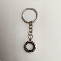 Close-up of a silver circular floating locket keychain with magnetic opening - 20mm / Silver