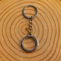 Detailed macro view of a silver round floating locket keychain on natural wood texture - 30mm / Silver