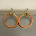 Detailopname van modieuze oranje glitter jelly creolen met gouden accenten en strass - Oranje