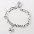 Detailed macro view of silver chain bracelet with snowflake charm and snap button base - Snowflake Pendant / Red