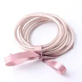 Primo piano di braccialetti buddisti in silicone rosa champagne con foglia d'oro - Oro champagne