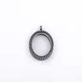 Detailed view of an oval gunmetal floating locket with a beaded bezel design. - Black
