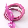 Set di tre bracciali rigidi in silicone magenta legati con un elegante nastro di raso - Magenta