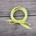 Set of multi-layered neon yellow silicone glitter bangles tied with a decorative ribbon bow - Yellow
