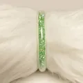 Encantador brazalete jelly de PVC verde claro con circonitas brillantes sobre piel blanca - Verde