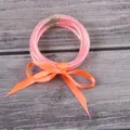 Elegant pink glitter silicone bangles set with a decorative bright orange ribbon bow - 5 Pieces / Orange