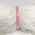 Brazalete de gelatina de PVC de 9mm relleno de circonitas rosas sobre fondo de piel sintética - Rosa