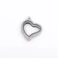 Close-up of a silver heart-shaped floating locket pendant with pavé set rhinestones. - Silver