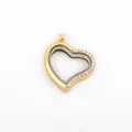 Detail of a gold heart-shaped floating locket with sparkling rhinestone accents. - Gold