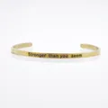 Goldener Edelstahl-Armreif mit der Gravur Stronger than you seem Botschaft. - Stronger than you seem Zitat
