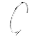 Detailed close-up of a silver stainless steel open bangle with an engraved quote - YOU ARE BORN TO BE REAL NOT TO BE PERFECT