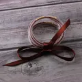 Detail of five-layer silicone jelly bangles with reddish-brown beads and ribbon. - 5 Pieces / Coffee