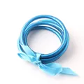 Close-up view of three blue silicone tube Buddhist bangles tied with a matching satin ribbon. - Light Blue