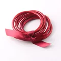 Close-up of red translucent silicone tube bangles tied with a dark red ribbon - 65mm / 6mm / Burgundy
