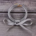 Gros plan de trois bracelets en silicone pailleté argent avec un nœud en ruban satin - Ensemble à 3 couches / Argent