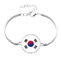 Detailansicht eines silberfarbenen Armbands mit südkoreanischem Flaggen-Cabochon - Legierungskettenstil