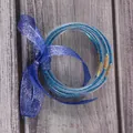 Detailopname van blauwe glitter siliconen armbanden vastgebonden met een decoratief lint - 5 Stuks / Hemelsblauw (JB604)