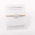 Detailweergave van zilveren puzzelarmband op een Autism Awareness-boodschap kaart cadeau - Goud