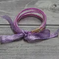 Set de brazaletes de silicona con purpurina magenta atados con una cinta morada decorativa - Púrpura Fucsia
