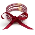 Close-up of pink glitter-filled silicone jelly bangles with a red silk ribbon bow - 5 Pieces / Dark Red