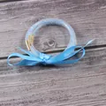 Close-up of three-layer blue rhinestone jelly bangles with a satin ribbon bow - 3-Layer Set / March Light Blue
