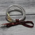 Primer plano de una pulsera de cinco capas de silicona con cuentas y un lazo de raso marrón - Café