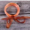 Detailopname van oranje glitter siliconen armbanden met een rode strik van gaaslint. - 5 Stuks / Oranje (JB604)