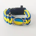 Close-up of paracord survival bracelet with Ukraine flag charm and tactical buckle. - Badge Decorative Style / Ukraine Blue Yellow